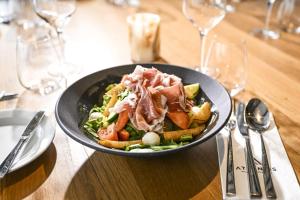 Eine Schüssel Salat mit Fleisch und Gemüse auf einem Tisch in der Unterkunft Hotel Atlantis in Brünn