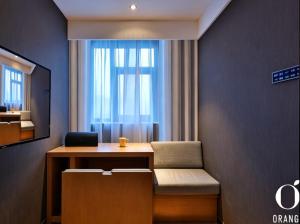 a room with a desk with a laptop and a window at Orange Hotel Beijing Shangdi Huandao in Beijing