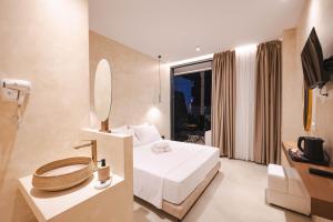 a hotel room with a bed and a mirror at Heavenly Rest Luxury Hotel in Sarandë