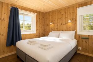 a bed in a room with wooden walls and a window at Unique mountain retreat in Gol in Gol