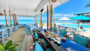 a restaurant with blue tables and chairs and the ocean at Combo Beach Hotel Samui in Chaweng