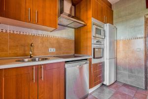 a kitchen with a sink and a white refrigerator at La Adrada Green Escape with pool in La Adrada +24 photos