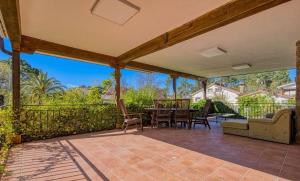 a patio with a table and chairs and a fence at La Adrada Green Escape with pool in La Adrada