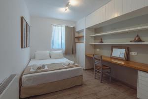 ein Schlafzimmer mit einem Bett, einem Schreibtisch und einem Stuhl in der Unterkunft Stunning View - Agapi's Houses in Andiparos + 53 Fotos