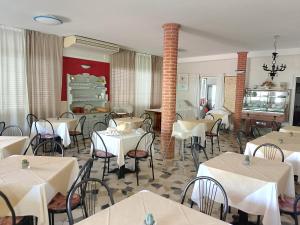 a dining room with white tables and chairs at Albergo La Maria in Fiumaretta di Ameglia