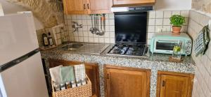 a small kitchen with a stove and a microwave at La Corte di mezzo in Corigliano dʼOtranto