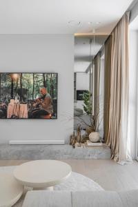 a living room with a white table and a picture on the wall at Refined luxury apartment surrounded by forest in Vilnius