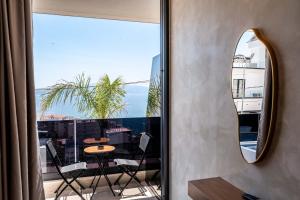 a mirror on a wall next to a balcony with a table at Heavenly Rest Luxury Hotel in Sarandë