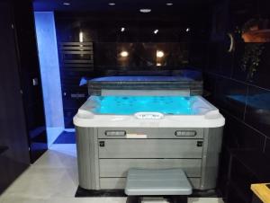 a jacuzzi tub in a room with a stool at L'Échappée Romantique & Spa Privatif in Foix