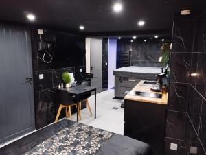a black bathroom with a bed and a kitchen at L'Échappée Romantique & Spa Privatif in Foix