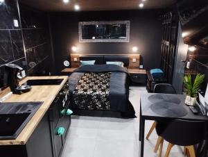 a bedroom with a bed and a table and a kitchen at L'Échappée Romantique & Spa Privatif in Foix