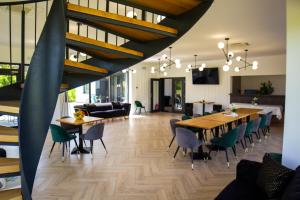 a living room with wooden tables and chairs at Pensiunea Qubik Praid in Ocna de Jos