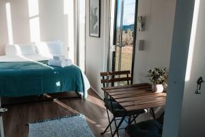 a bedroom with a bed and a table and a window at Hills and Herds by Tiny Away in Shannon Brook