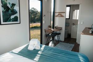 a bedroom with a bed with towels on it at Hills and Herds by Tiny Away in Shannon Brook