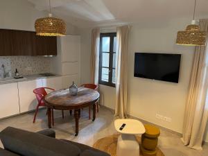 a living room with a table and a kitchen at Chez Elsa et Camille in Aigues-Mortes