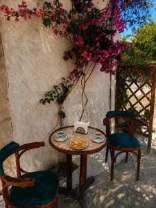 a table and two chairs and a table with flowers at Ancient Gortyna Home -Basilica & Mosaic View in Mitrópolis