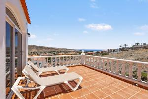 a balcony with two chairs and a view of the ocean at Villa Gabriela in Tarajalejo
