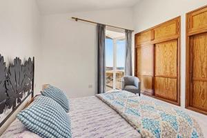 a bedroom with a bed and a large window at Villa Gabriela in Tarajalejo