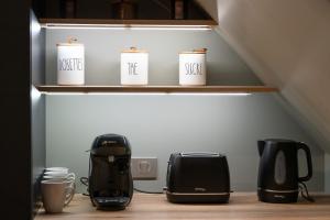a shelf with coffee cups and appliances in a kitchen at Escale de Giulia in Beaune