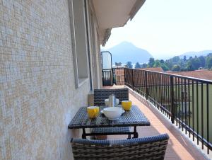 a table on a balcony with two yellow cups on it at Il Lago di Luciana in Intra