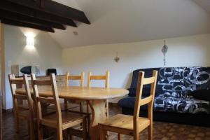 a dining room with a wooden table and chairs at Le génépi in Roubion +6 photos