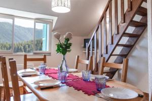 a dining room table with a vase of flowers on it at Le génépi in Roubion
