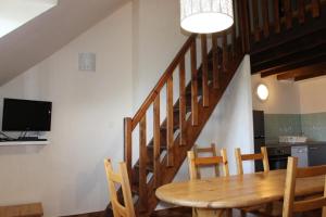 a dining room with a table and chairs and a staircase at Le génépi in Roubion