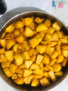 a pan full of potatoes on a table at Ardi Selimaj in Valbonë