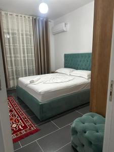 a bedroom with a bed with a blue headboard at Enes apartament in Krujë