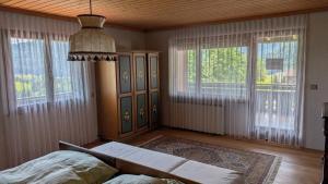 a bedroom with a bed and windows and a chandelier at Ferienhaus Buchen in Schwarzenberg