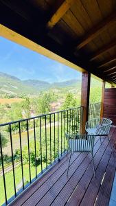 a porch with a bench on a balcony with a view at Leyendas Del Pirineo Turismo Rural in Fiscal