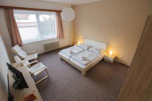 - une chambre avec un lit, deux chaises et une fenêtre dans l'établissement Penzion Starr, à Havlíčkův Brod
