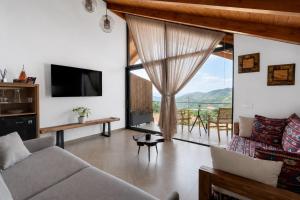 a living room with a couch and a large window at Vila Harmoni Roshnik in Roshnik