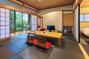 a room with a bed and a table and chairs at Onyado Satsuki in Tamana