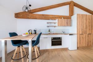 a kitchen with a wooden table and blue chairs at Vina Rhona - Loft de charme entre Rhône et Vignes climatisé in Condrieu