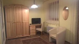 a room with a desk with a computer and a tv at Pongrácz Apartman in Zirc