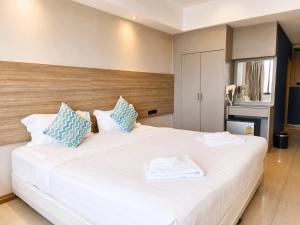 a bedroom with a large white bed with blue pillows at Avana Laem Chabang Boutique Hotel in Ban Laem Chabang +55 photos