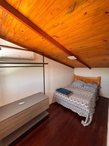a bed in a room with a wooden ceiling at Casa Bouganville in Monte das Gameleiras +9 photos