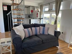 a living room with a blue couch with pillows at The Old Boathouse in Southwell