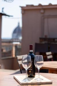a bottle of wine and two wine glasses on a table at Bohemian Palace Florence in Florence