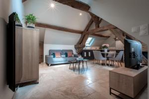 a living room with a blue couch and a tv at Escale de Giulia in Beaune +17 photos