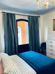 a bedroom with a blue bed and a window at Agriturismo Colle Donatucci in Castagneto Carducci +46 photos