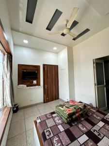 a bedroom with a bed and a ceiling fan at The Empire Hotel in Sewāni