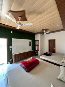 a bedroom with two beds and a ceiling fan at The Empire Hotel in Sewāni