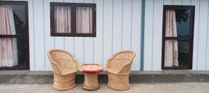 two pairs of wicker shoes and a table in front of a house at Pahadi aangan in Bhīm Tāl