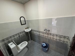 a bathroom with a toilet and a sink at Pahadi aangan in Bhīm Tāl
