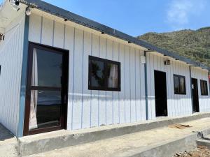 a white building with windows on the side of it at Pahadi aangan in Bhīm Tāl