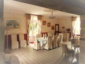 a dining room with a table and chairs in it at Le Manoir "Aux Douves" in Bazoges-en-Paillers