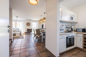 a kitchen with white cabinets and a dining room at Rauchschwalbe in Zingst
