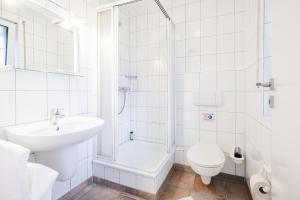 a white bathroom with a sink and a toilet at Rauchschwalbe in Zingst +26 photos